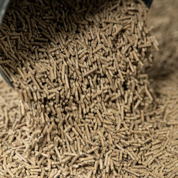 Pure Feed Meadow Mash pellets being poured, showcasing their soft, digestible texture and high-fibre content for equine nutrition.