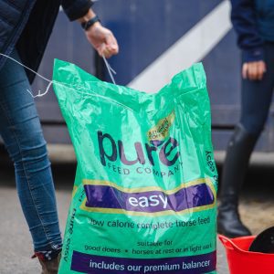 Pure Feed Easy – Low-Calorie Horse Feed for Light Work & Rest Pure Feed Easy horse feed bag being opened, designed for good doers and horses in light work or at rest.